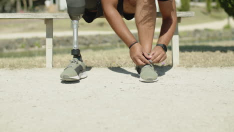 Vorderansicht-Eines-Mannes-Mit-Bionischem-Bein,-Der-Vor-Dem-Radfahren-Schnürsenkel-Bindet